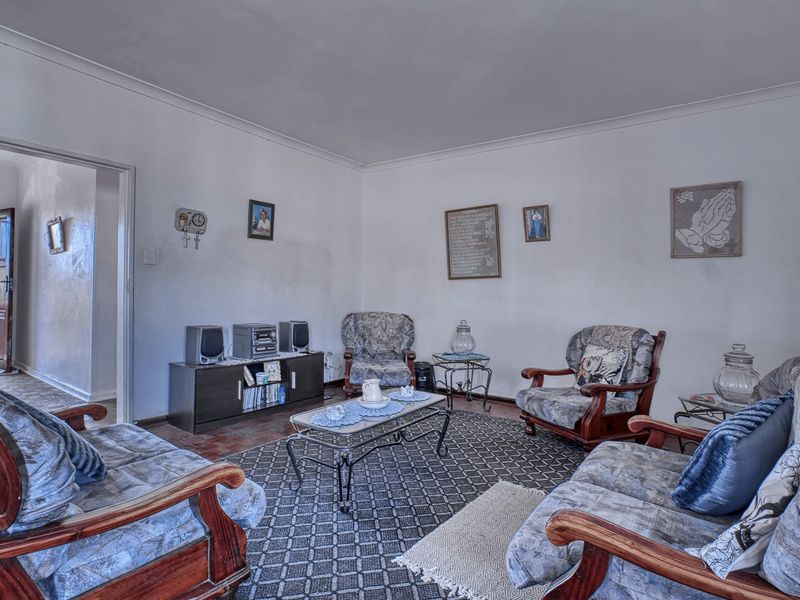 A living room featuring coved ceilings and neutral wall finishes, offering a functional space ready for modernization and cosmetic updates.
