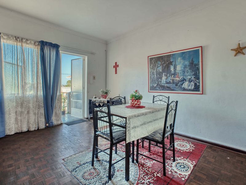 Dining area featuring traditional parquet flooring and direct access to an outdoor balcony through a sliding glass door.