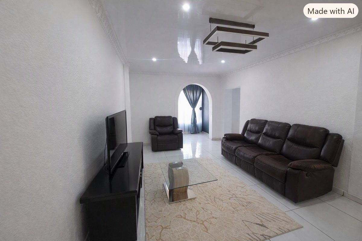 A bright living room featuring glossy ceilings, coved cornicing, tiled flooring, and a distinctive arched entryway.