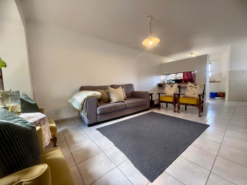 Open plan living area featuring tiled flooring and a convenient pass-through window connecting to the kitchen space.
