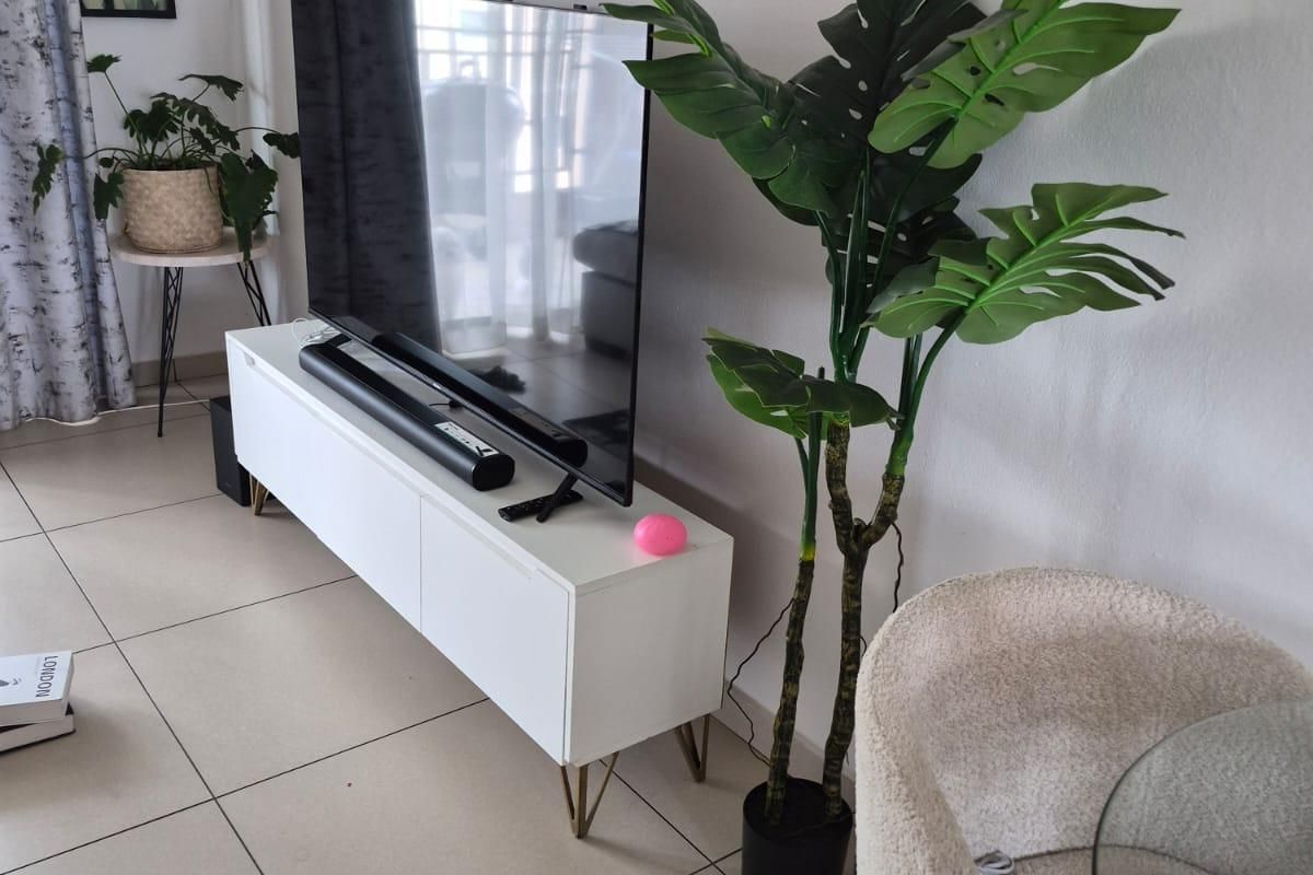 A bright living room area featuring neutral tiled flooring and clean wall finishes, providing a versatile space for relaxation.