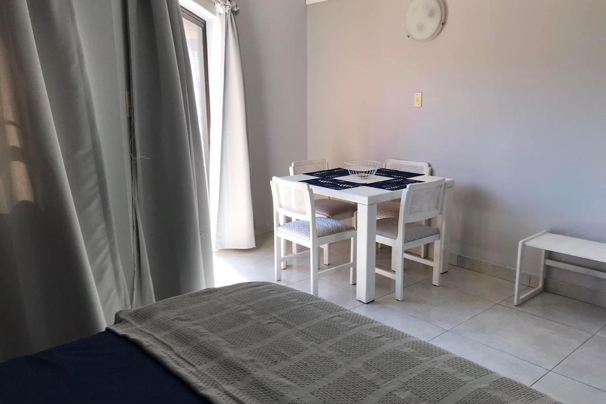 A bedroom featuring tiled flooring and a sliding glass door providing natural light and access to the exterior.