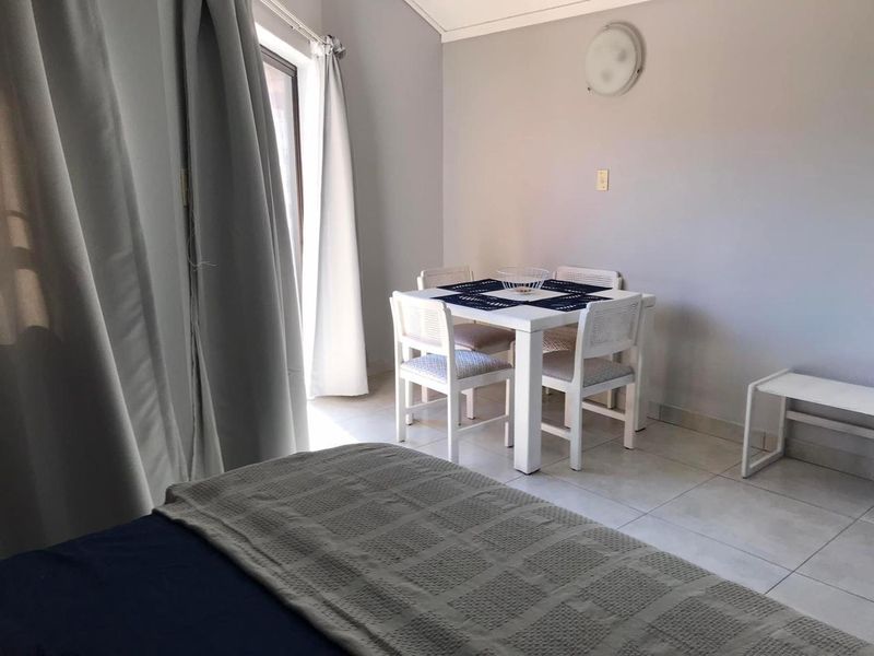A bedroom featuring tiled flooring and a sliding glass door providing natural light and access to the exterior.
