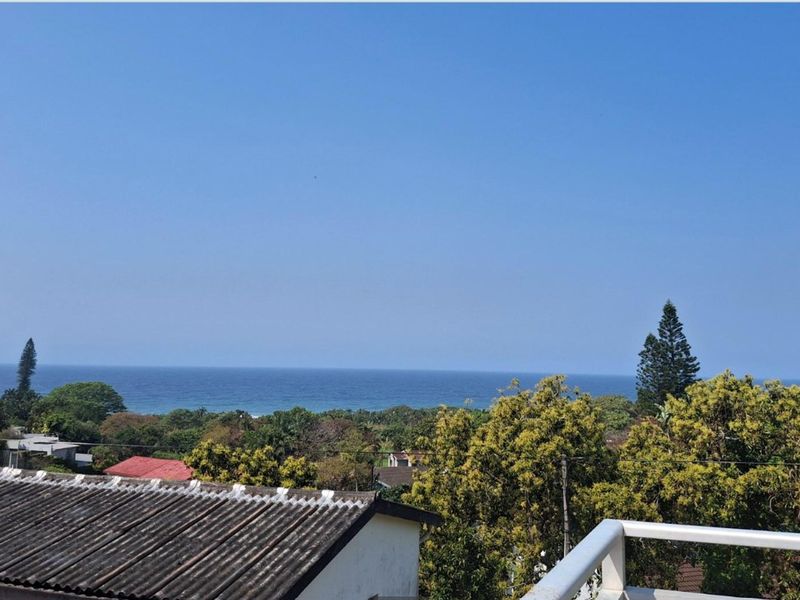 A scenic elevated view overlooking the surrounding neighborhood with a clear horizon line of the ocean.