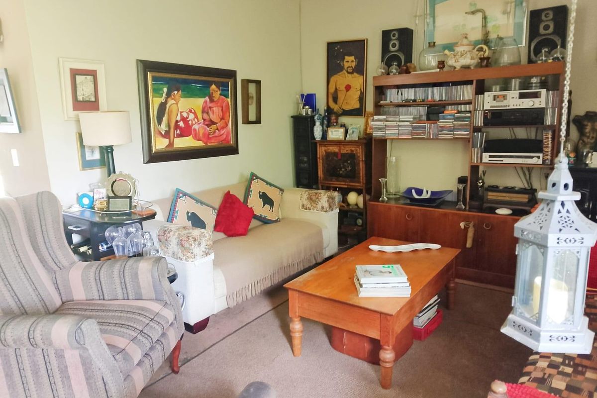 A comfortable living room featuring carpeted flooring and classic coving, providing a functional and lived-in space.