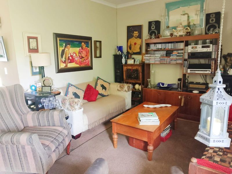A comfortable living room featuring carpeted flooring and classic coving, providing a functional and lived-in space.