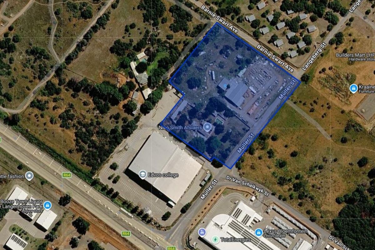 Aerial view of a commercial property site highlighting the building footprint, parking area, and surrounding street access in a suburban location.