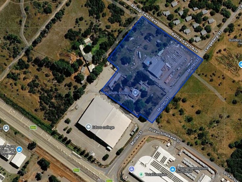 Aerial view of a commercial property site highlighting the building footprint, parking area, and surrounding street access in a suburban location.