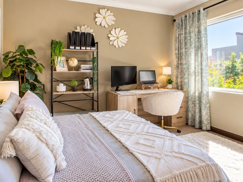 A well-lit bedroom featuring a large window, neutral wall tones, and classic coving, providing a comfortable and inviting living space.