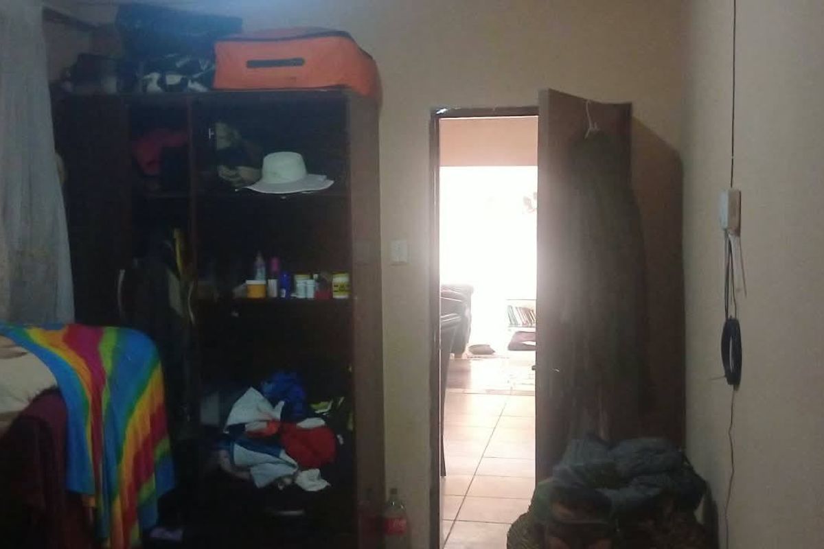 A bedroom interior featuring a built-in wardrobe and access to an adjacent living area.