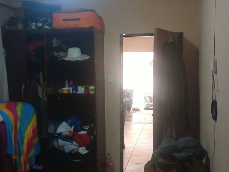 A bedroom interior featuring a built-in wardrobe and access to an adjacent living area.