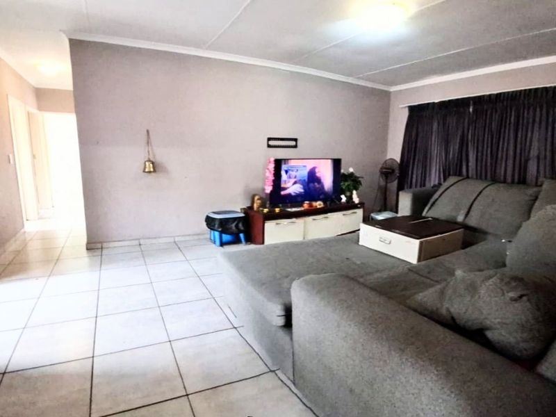 A living room featuring tiled flooring and neutral wall finishes, providing a functional and open space for relaxation.