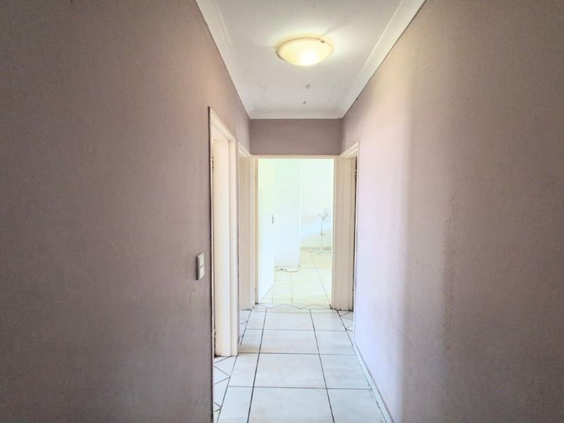 A functional hallway featuring tiled flooring and neutral wall finishes, providing access to adjacent rooms within the townhouse.