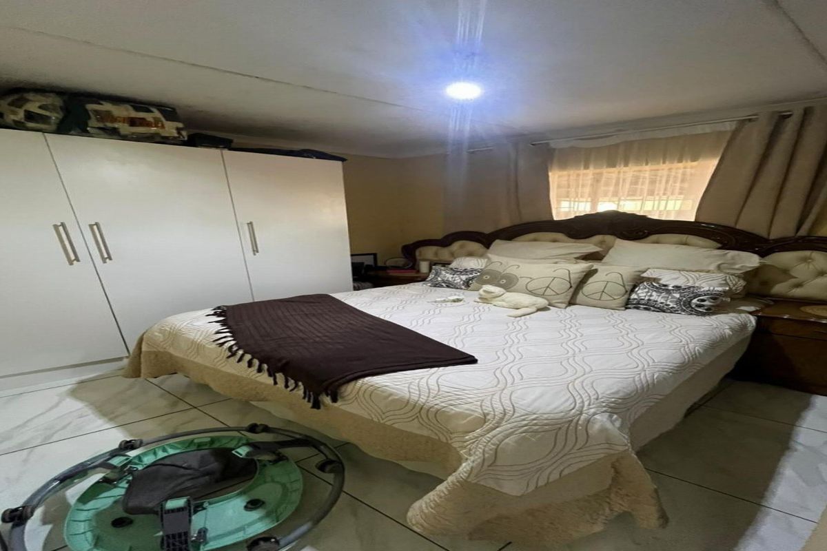 A bedroom featuring tiled flooring and a built-in wardrobe, providing functional storage space.