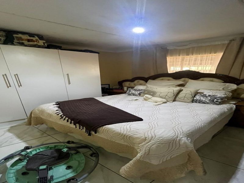 A bedroom featuring tiled flooring and a built-in wardrobe, providing functional storage space.
