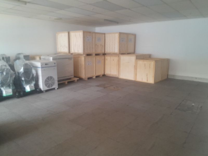 A functional industrial utility space featuring tiled flooring and a suspended ceiling, currently utilized for storage.
