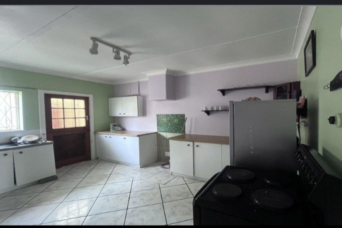 A dated kitchen featuring tiled flooring, built-in cabinetry, and laminate countertops, offering potential for a modern renovation to enhance functionality and aesthetic appeal.