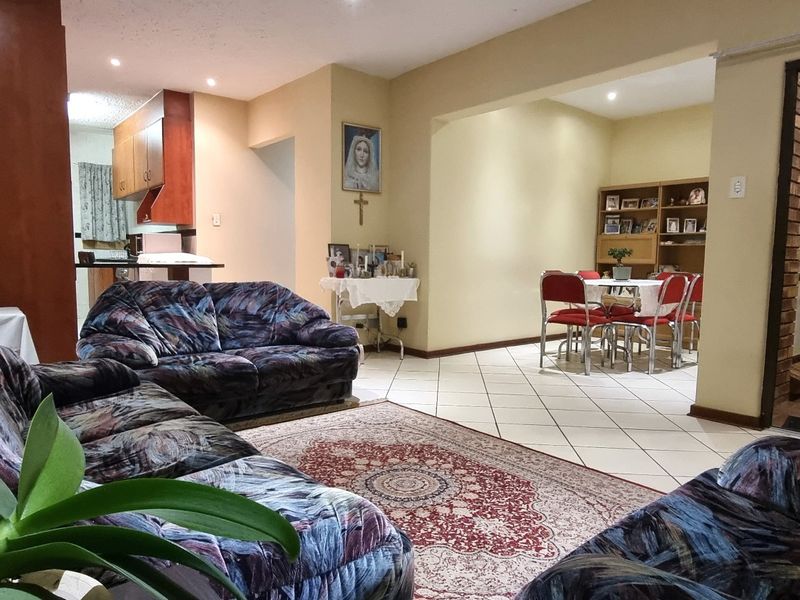 Spacious open-plan living and dining area featuring tiled floors, recessed lighting, and a seamless flow into the adjacent kitchen space.