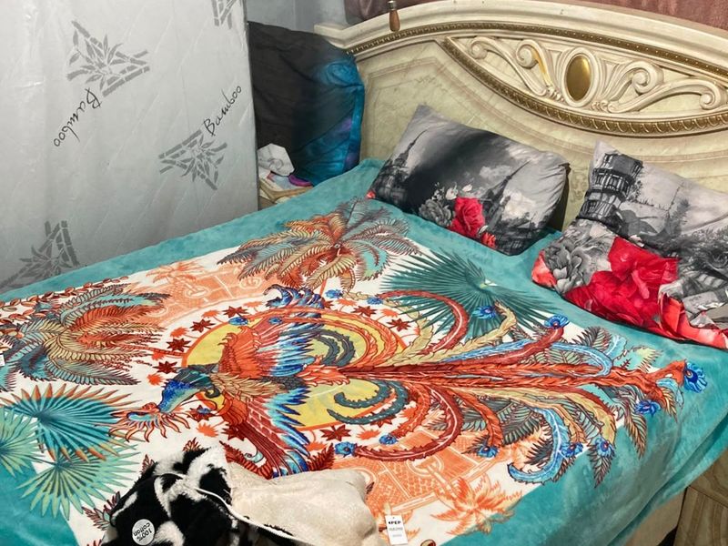 A bedroom featuring an ornate headboard, captured in a casual, lived-in setting.