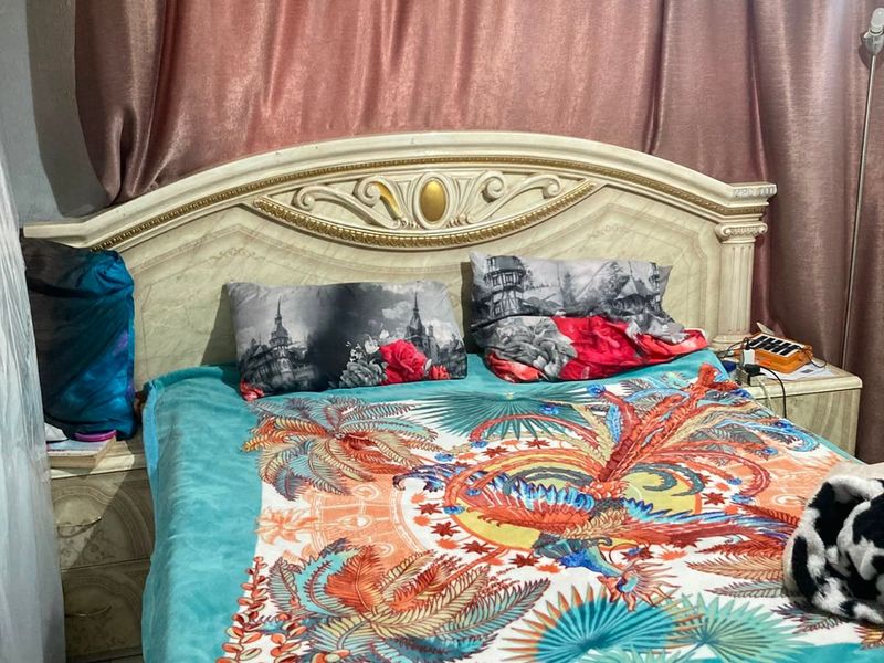 A bedroom featuring a decorative headboard and integrated bedside cabinetry, providing a functional sleeping space.