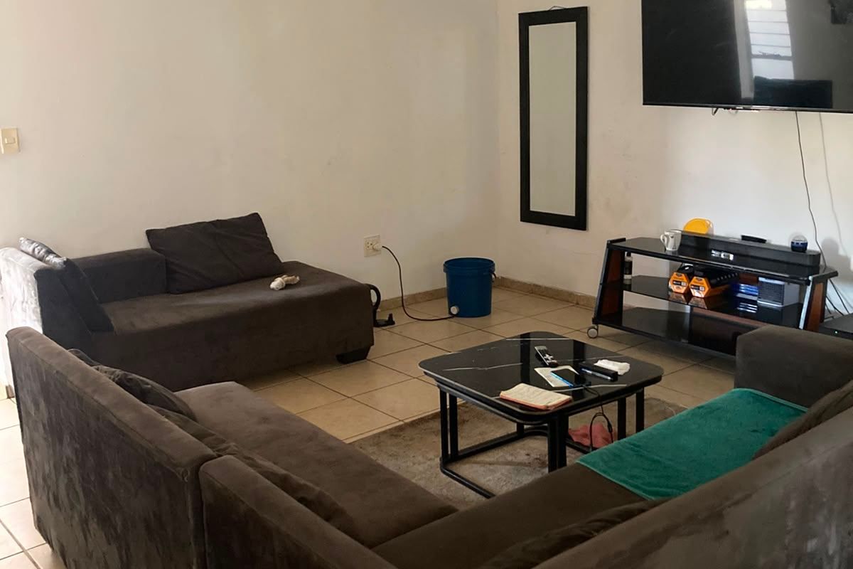 A living room featuring tiled flooring and neutral wall finishes, providing a functional space for relaxation.