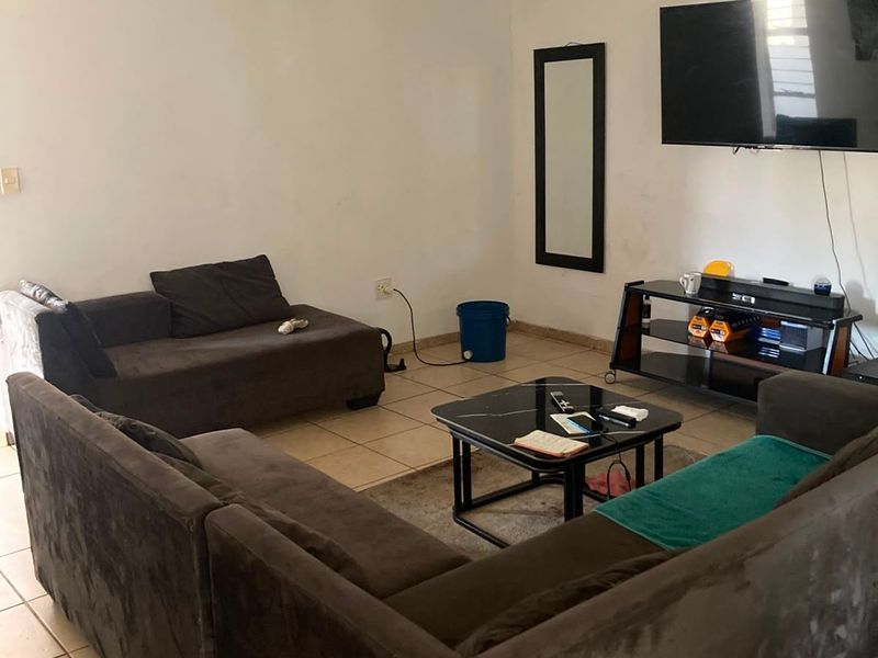 A living room featuring tiled flooring and neutral wall finishes, providing a functional space for relaxation.