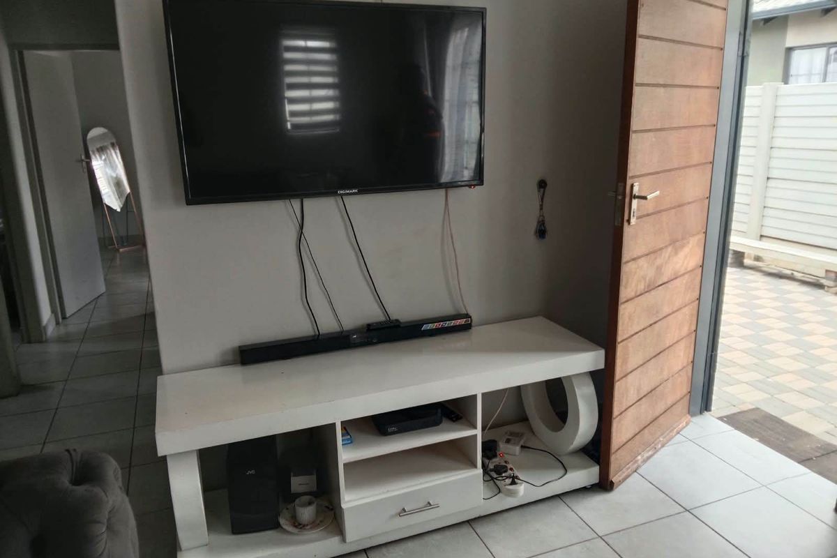 Living area featuring tiled flooring and direct access to an outdoor patio through a wooden door.
