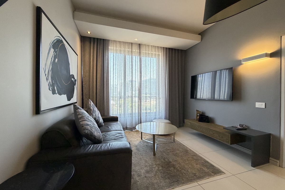 A modern, well-maintained living room featuring tiled floors, a floating media console, and large sliding glass doors that provide ample natural light.