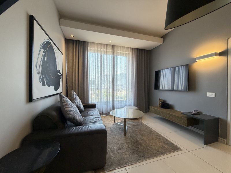 A modern, well-maintained living room featuring tiled floors, a floating media console, and large sliding glass doors that provide ample natural light.