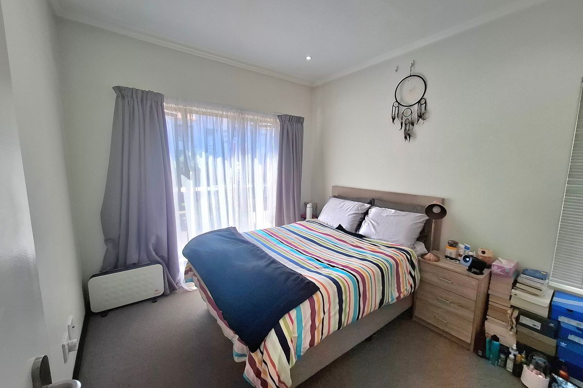 A functional bedroom featuring carpet flooring, recessed downlighting, and a sliding glass door providing access to an outdoor area.