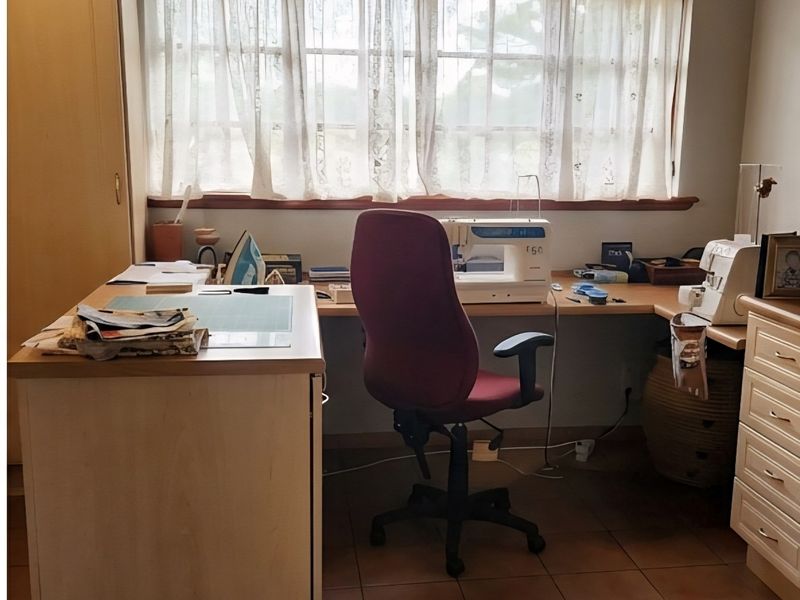 A functional home office space featuring built-in desk cabinetry and durable tiled flooring, offering a practical area for work or hobbies.