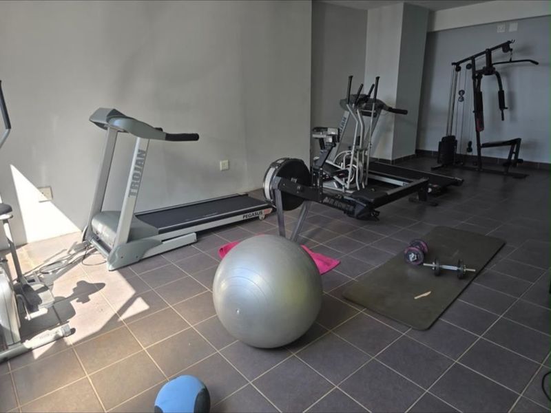 A dedicated home gym space featuring tiled flooring and ample room for various fitness equipment.