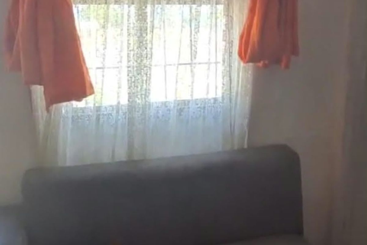 A living room area featuring a window with curtains.