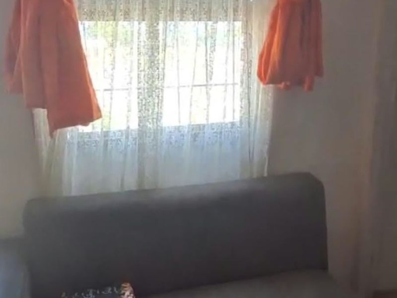 A living room area featuring a window with curtains.