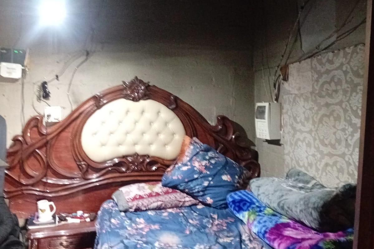 A bedroom featuring unfinished wall surfaces and exposed electrical wiring, requiring significant renovation and cosmetic updates to improve the living space.