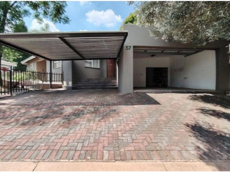Front exterior view featuring a paved driveway, a covered carport, and an integrated garage with concrete steps leading to the main entrance.