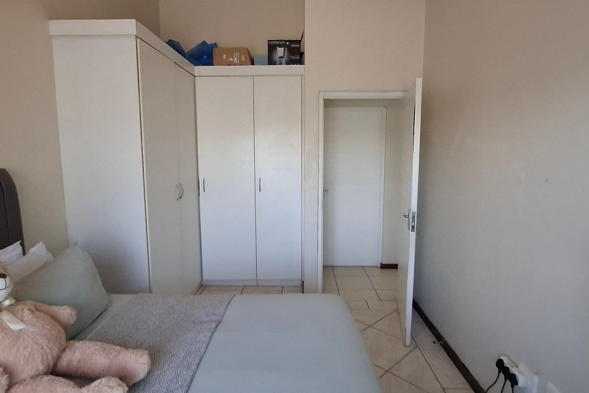 A bedroom featuring built-in cupboards and tiled flooring, providing functional storage and a neutral base for interior design.