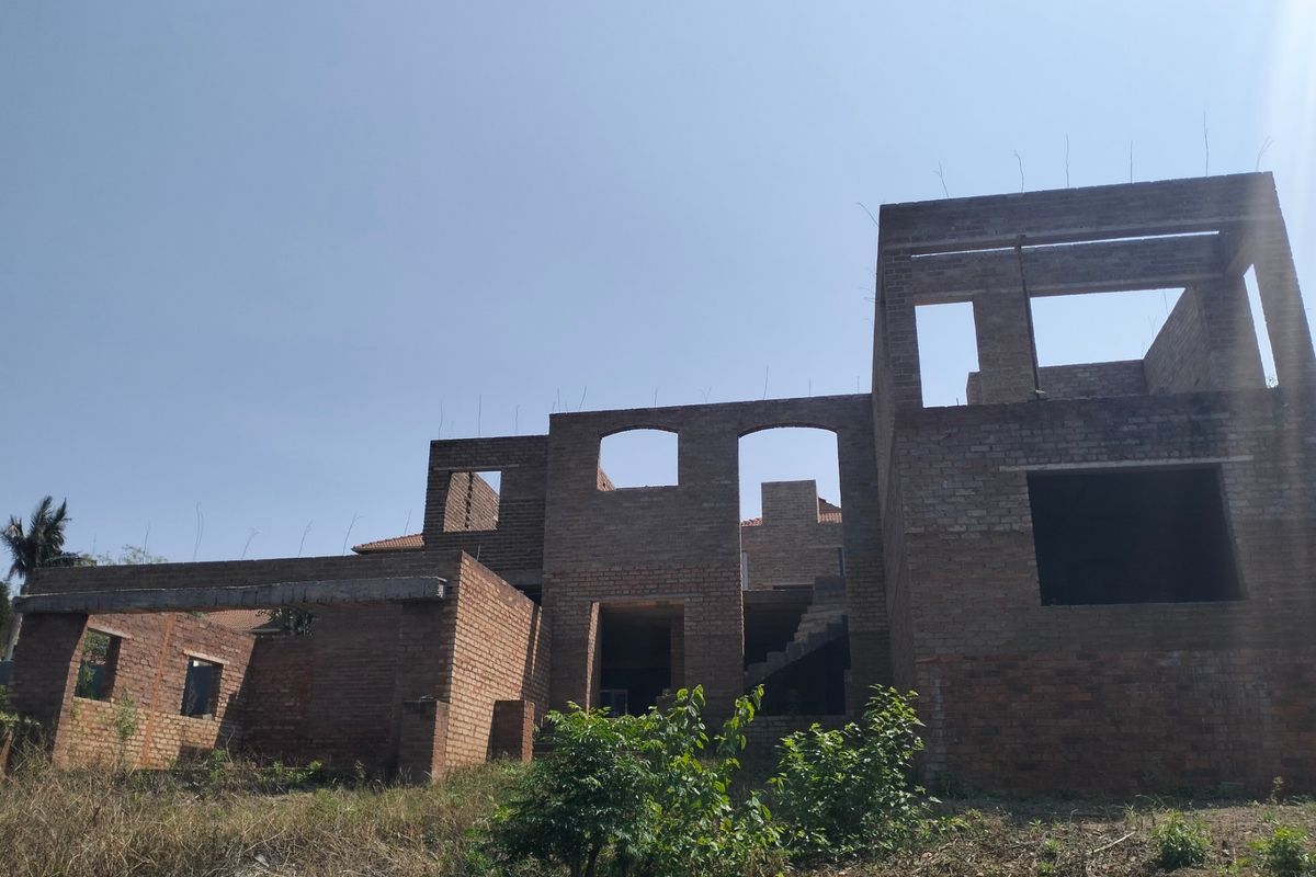 Rear elevation of a residential property currently under construction, featuring exposed brickwork and structural concrete elements.