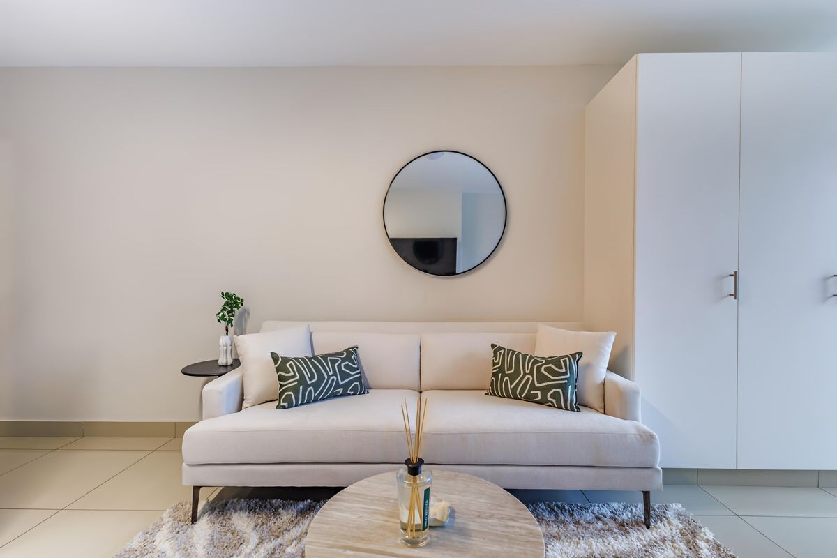 A well-maintained living area featuring neutral tiled flooring and a large built-in wardrobe, offering a clean and modern aesthetic.
