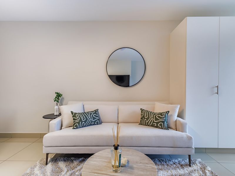 A well-maintained living area featuring neutral tiled flooring and a large built-in wardrobe, offering a clean and modern aesthetic.