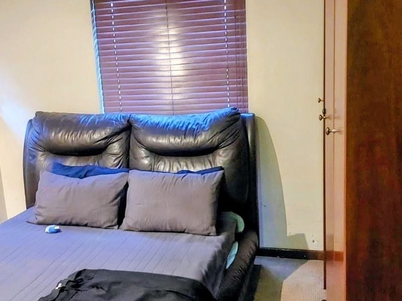 A bedroom featuring a built-in wardrobe and venetian blinds, providing a functional space with standard finishes.