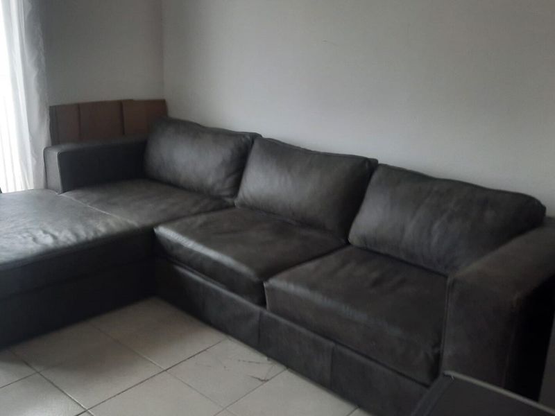 A living room area featuring tiled flooring and neutral wall finishes, providing a functional space for relaxation.