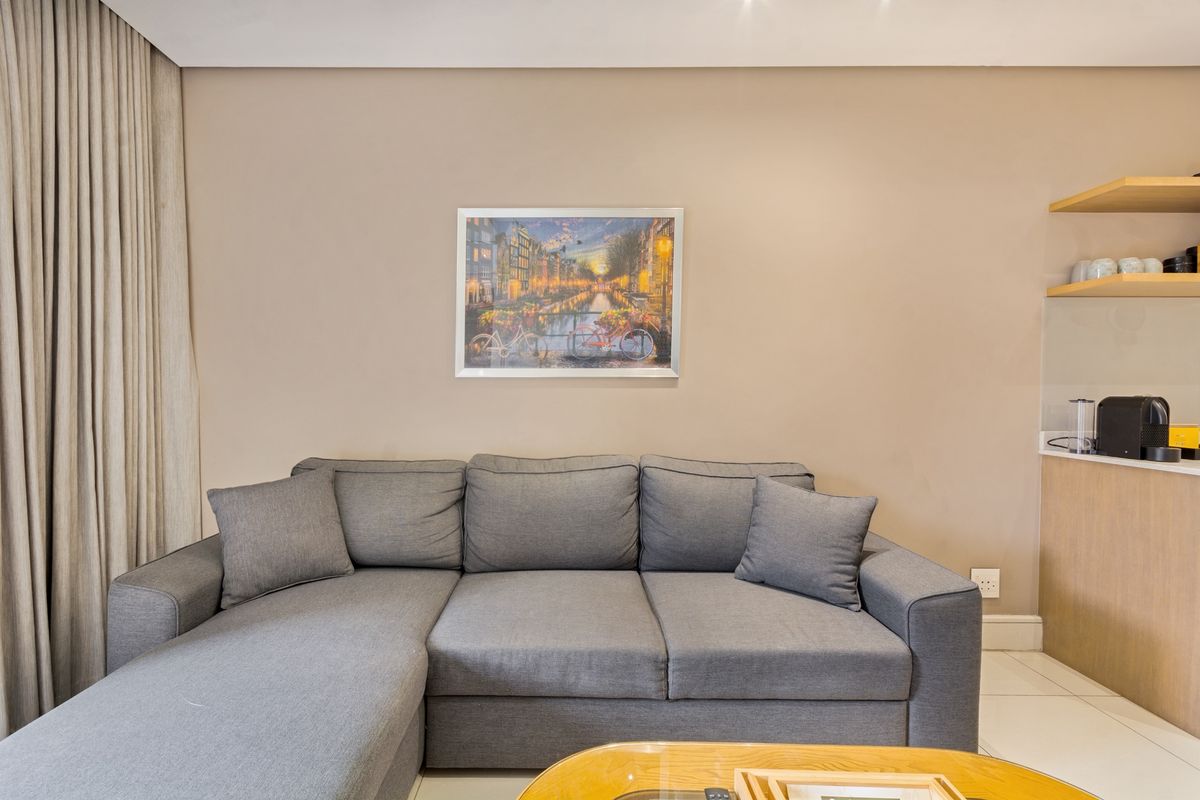 A well-maintained living area featuring neutral wall tones, tiled flooring, and built-in shelving, providing a clean and functional space.
