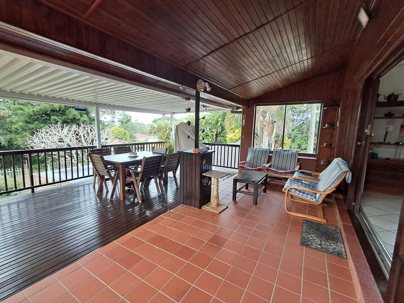 Spacious covered patio featuring a combination of tiled and timber decking, a built-in bar, and expansive views, perfect for outdoor entertaining.