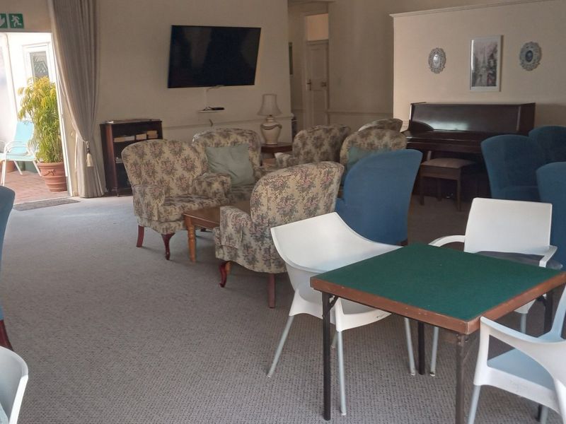 Spacious communal living area featuring carpeted flooring and large sliding glass doors providing access to an outdoor patio space.