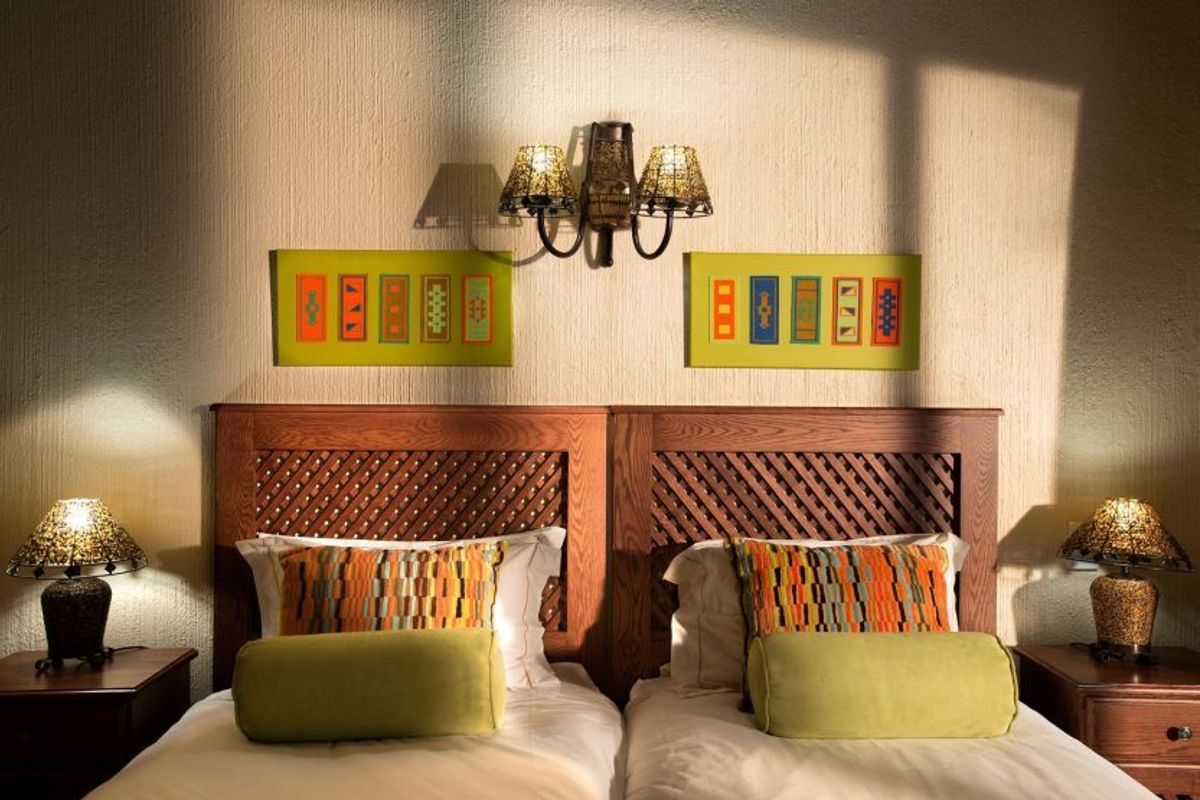 A well-lit bedroom featuring a textured wall finish and a decorative wall-mounted light fixture above the bed area.