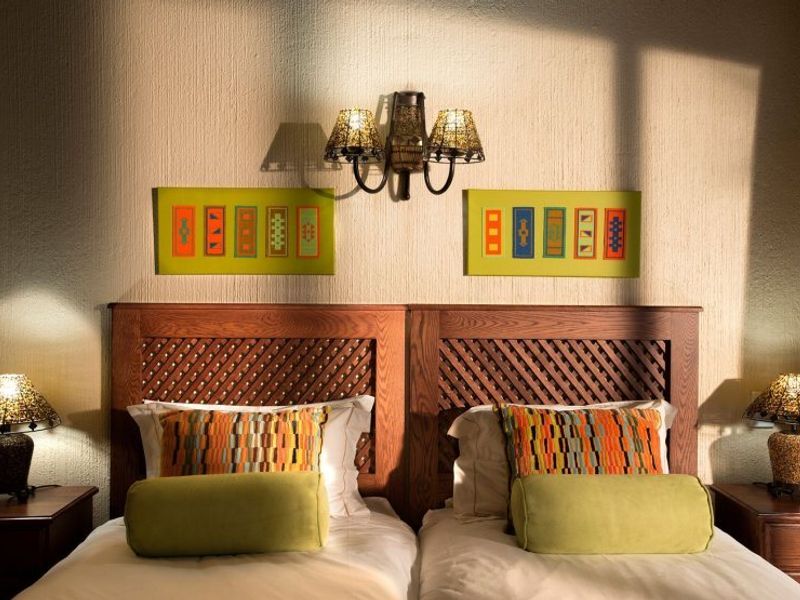 A well-lit bedroom featuring a textured wall finish and a decorative wall-mounted light fixture above the bed area.