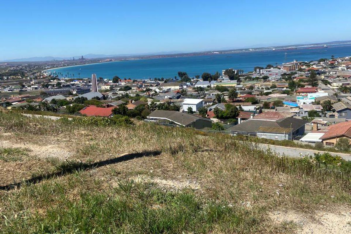 An elevated view overlooking the coastal town and bay, showcasing the expansive landscape and surrounding residential area.