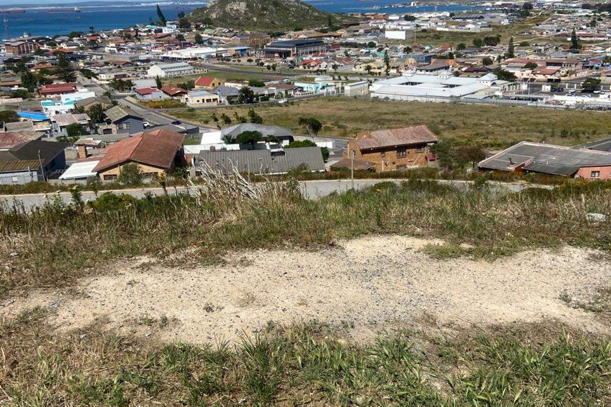 Elevated view overlooking the surrounding coastal town, residential area, and distant ocean horizon from the vacant land plot.