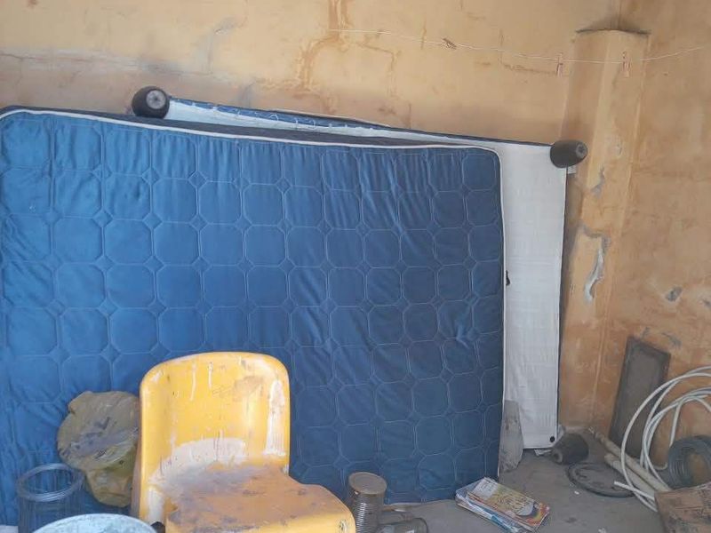 A utility space or storage area featuring unfinished wall surfaces and ceiling, requiring maintenance and cosmetic repairs.